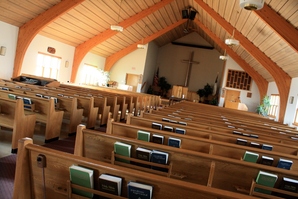 The sanctuary at Alto Christian Reformed Church, with wooden pews and a cross at the front